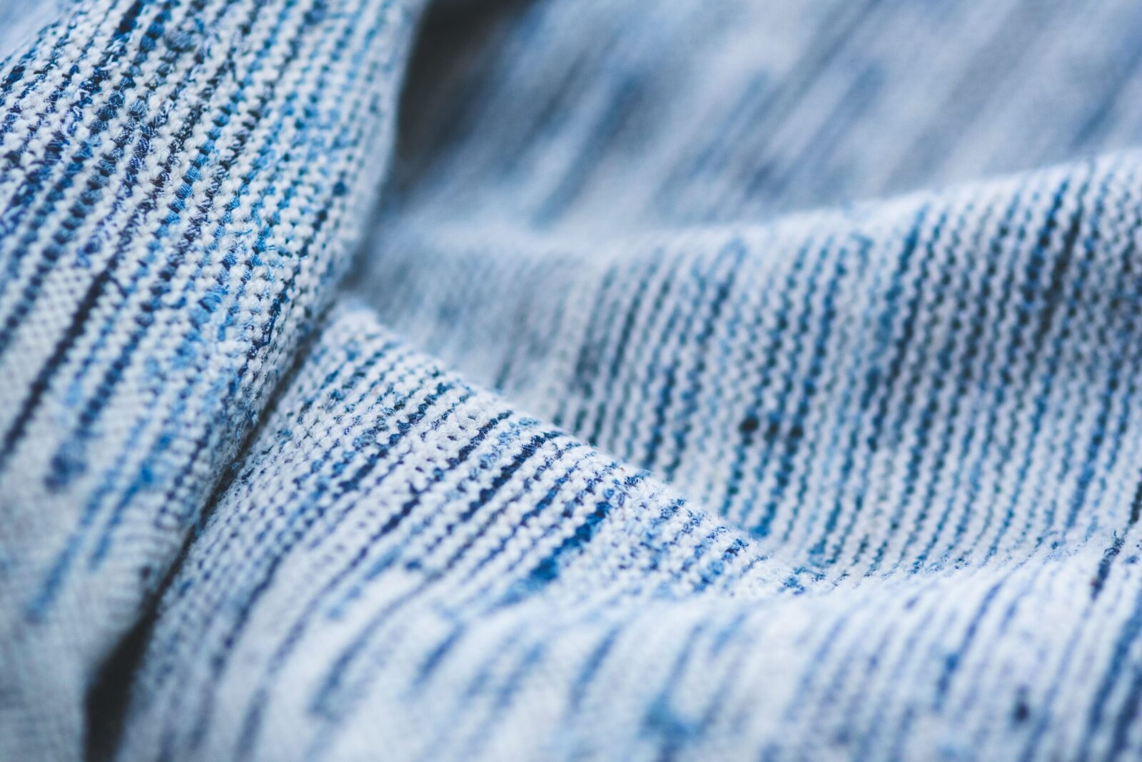 Macro shot of a blue striped textile showing detailed texture and pattern.